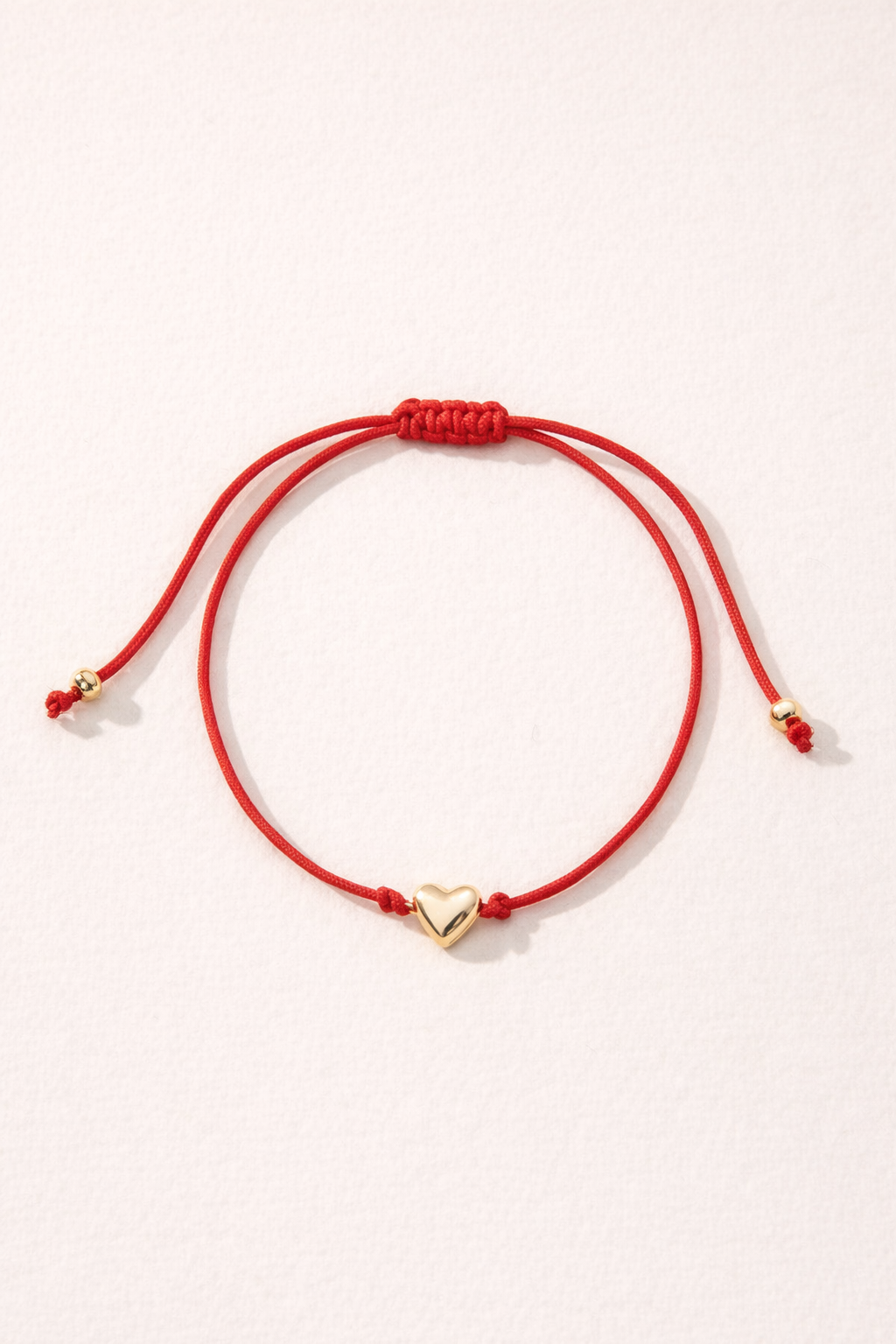 Bracelet cœur en corde rouge ou noire de MoonRose Boutique, bijou délicat et tendance, affichant un pendentif en forme de cœur.