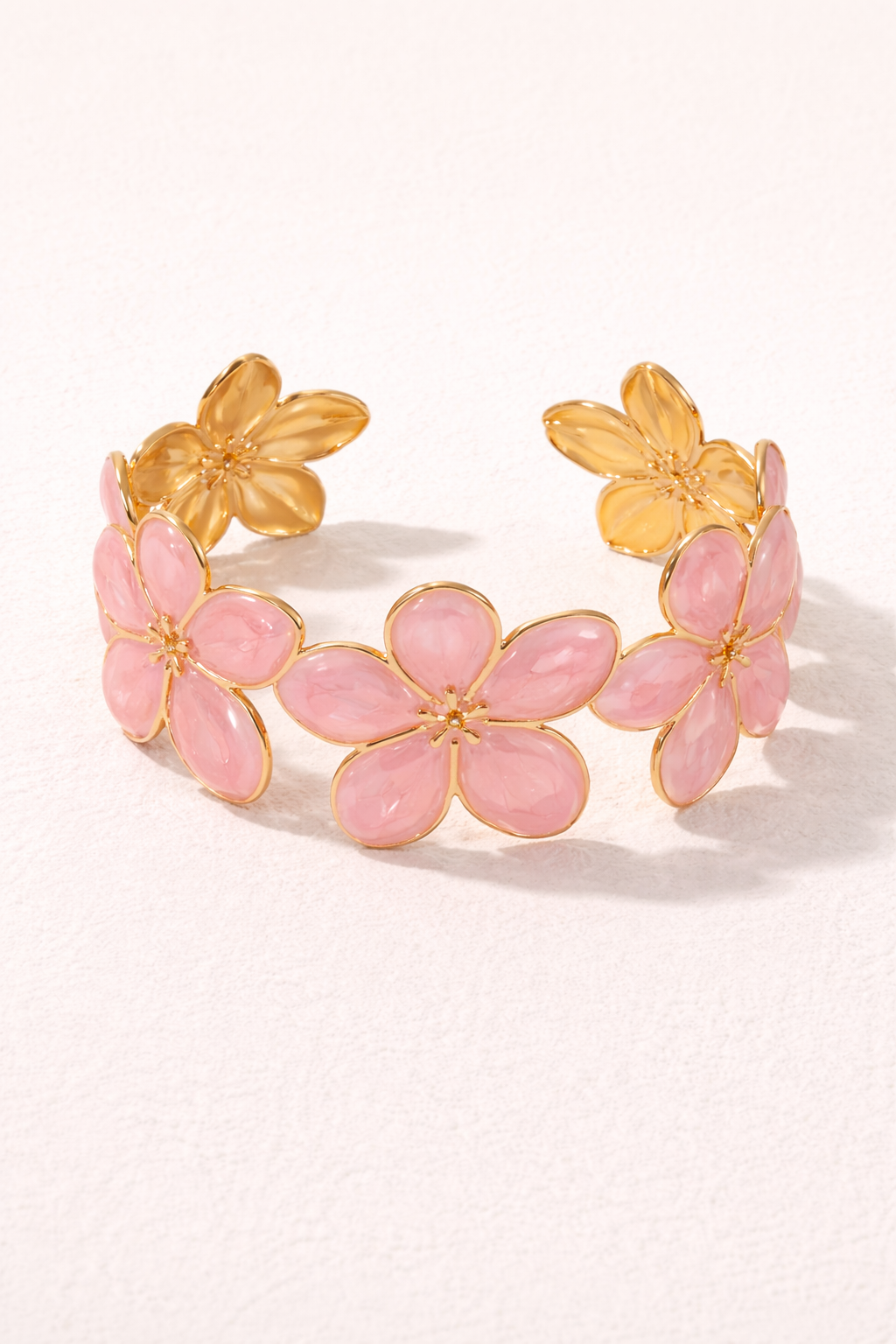 Bracelet manchette en métal avec fleurs sculptées, finition émail blanc ou rose, bijou élégant de MoonRose Boutique.
