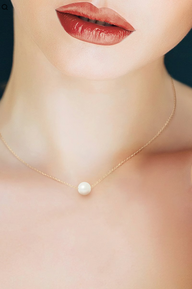 Collier MoonRose La Perle de Foi en or avec une perle élégante, porté sur une femme avec une chaîne fine et délicate.