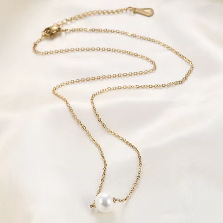 Collier MoonRose La Perle de Foi en or avec perle élégante, porté sur un fond blanc, mettant en valeur le bijou sophistiqué.